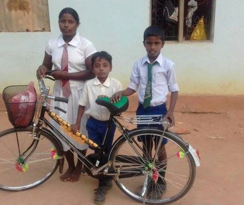 Vision of Love donates a bicycle to a schoolgirl